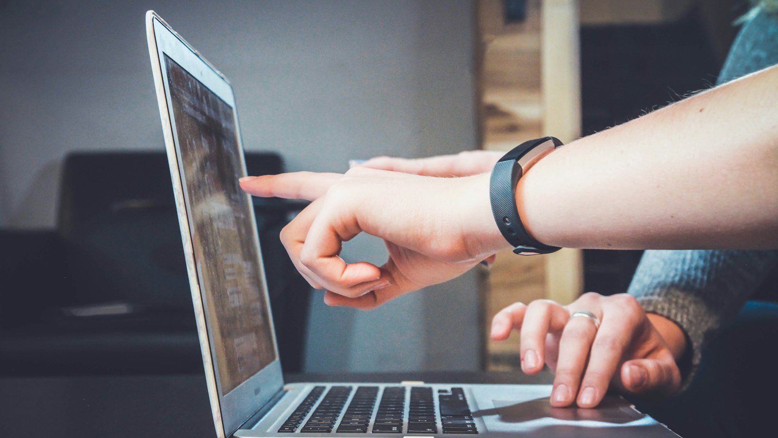 Person pointing at a laptop screen while planning video content
