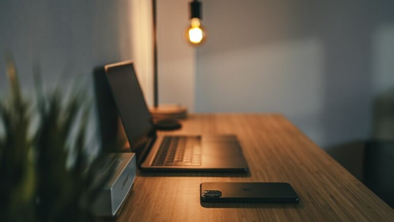 Minimal wooden desk with a laptop and a warm desk lamp