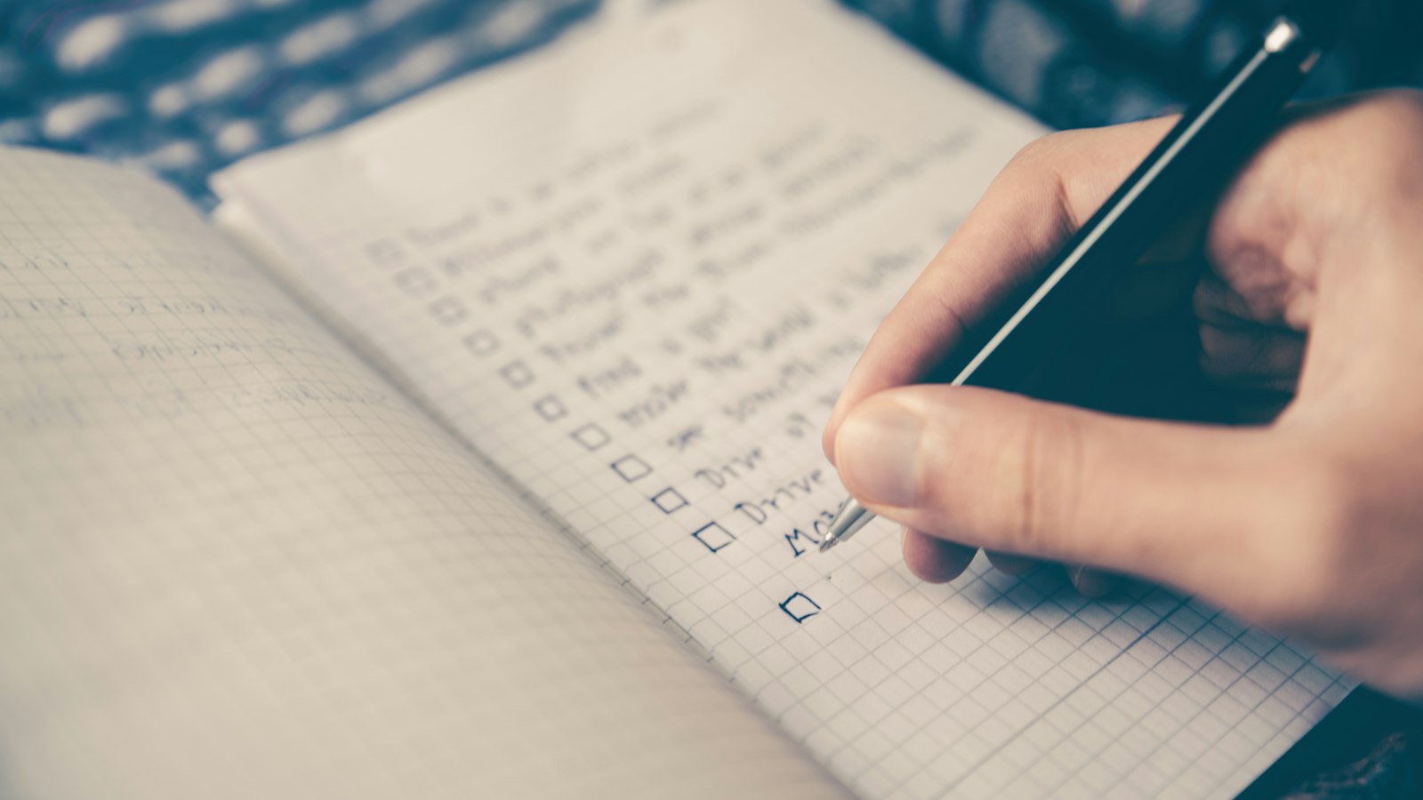 Hand writing a checklist in a notebook
