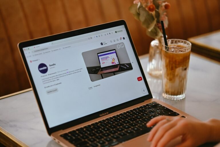 Laptop on a cafe table showing a Pinterest business profile